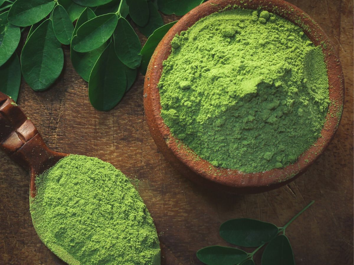 Moringa leaf powder in a wooden bowl